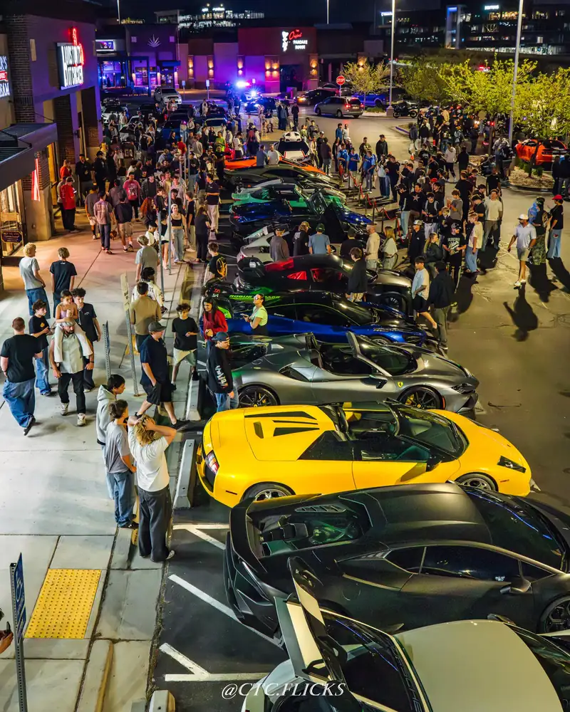 A packed night meet: rows of cars under parking-lot lights